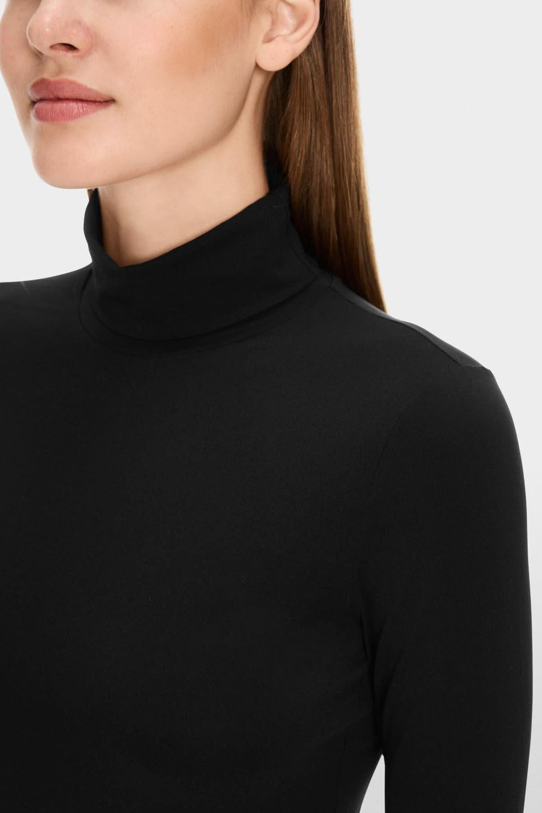 Chandail noir à col roulé, confortable et légèrement cintré, idéal pour une superposition élégante.