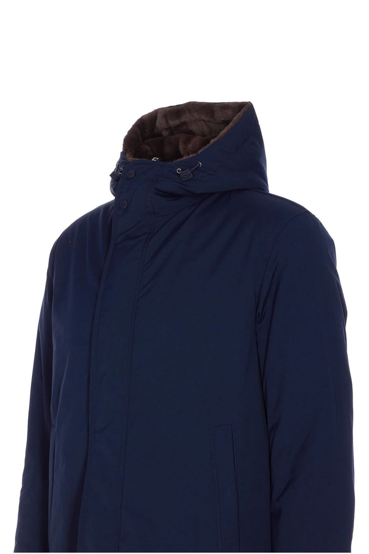 Manteau matelassé pour homme avec capuche doublée en fausse fourrure, couleur bleu marine, offrant style urbain et confort.