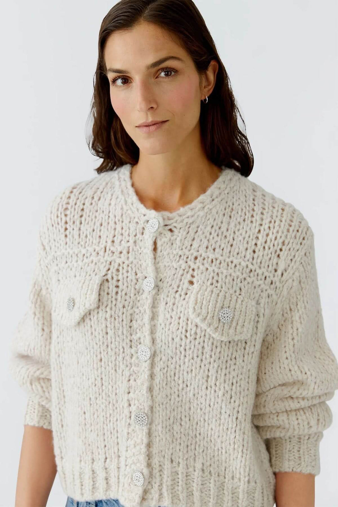 Veste en tricot épais à boutons bijoux avec maille ajourée et poches à rabat, idéale pour tenues chic et cosy en automne et hiver.