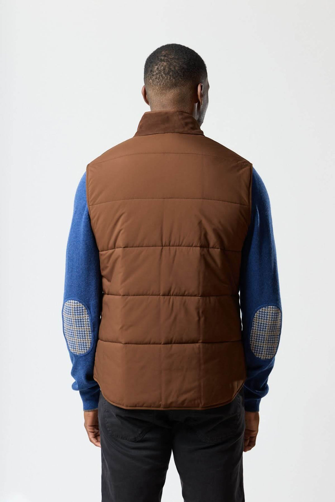 Homme portant une veste sans manches en simili suède marron de Waterville, vue arrière, élégance moderne et confort matelassé.