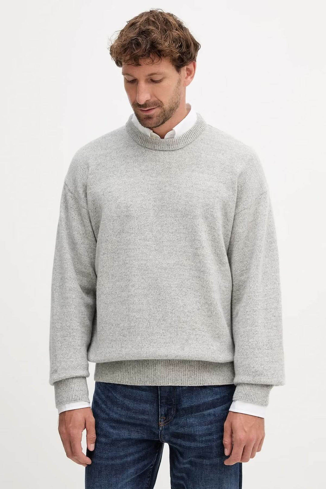 Homme portant un chandail en laine vierge coupe "oversize" gris avec finitions côtelées, confort moderne, laine certifiée sans mulesing.