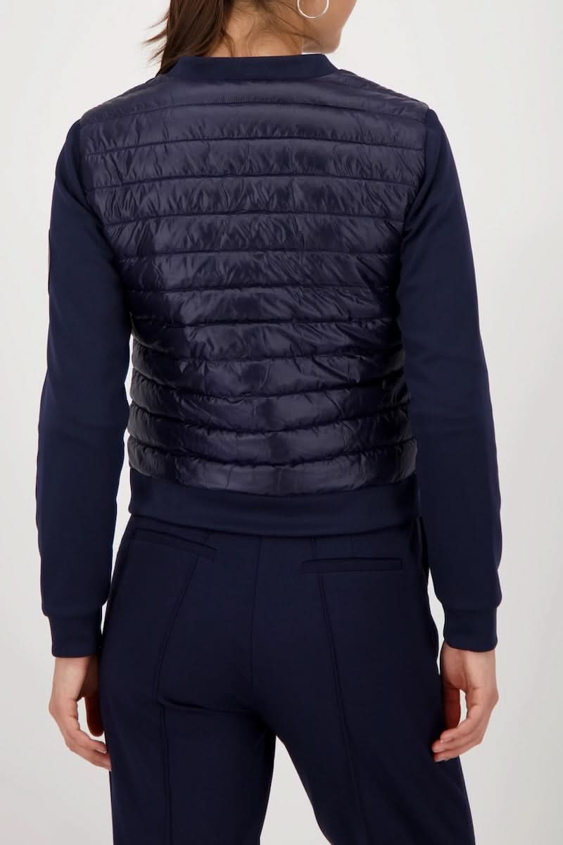 Alt Tag: Veste matelassée bimatière à fermeture éclair pour femme, vue de dos, combinaison de style sportif et confort.