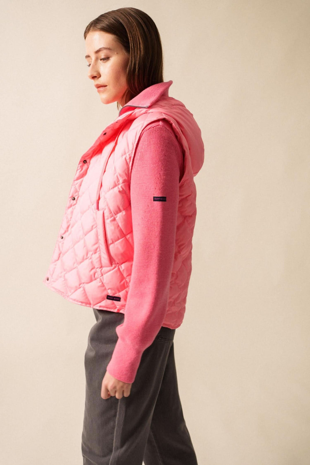Doudoune sans manche STE JODIE rose, au style sportif et féminin, avec capuche intégrée et zip latéral.