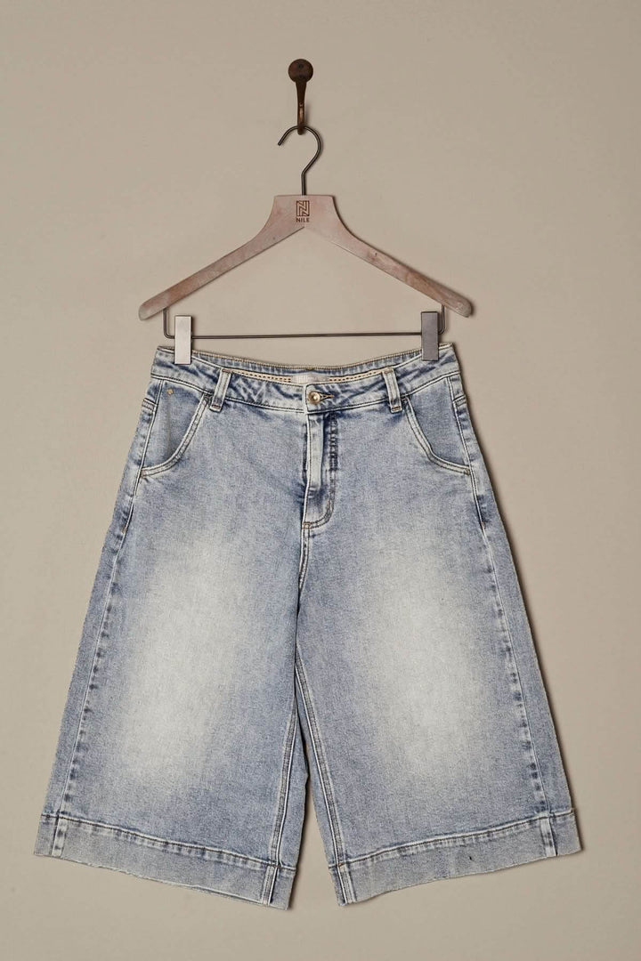 Bermuda en denim délavé, coupe ample, longueur genou, style décontracté, à accrocher sur un cintre.