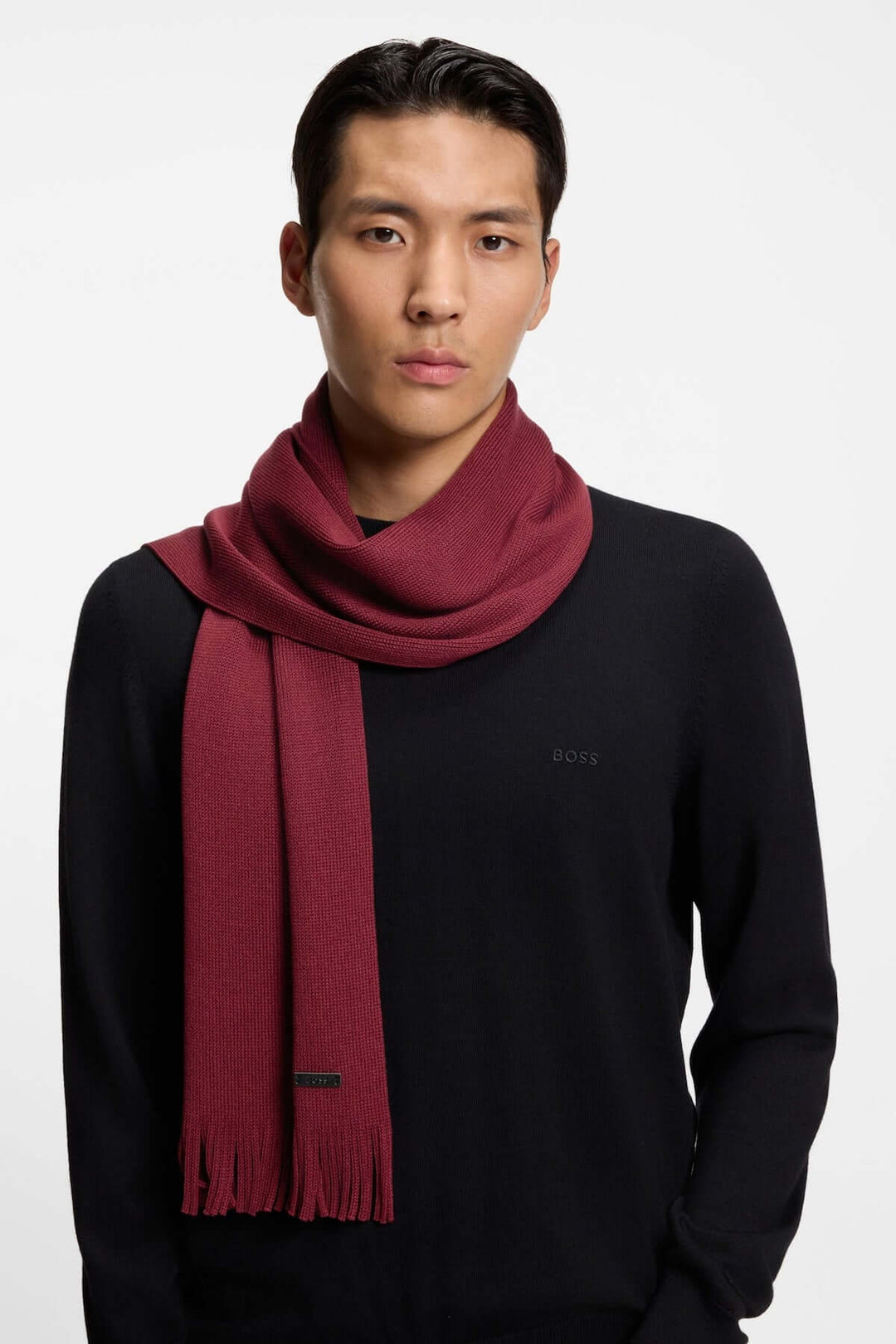Homme portant un Foulard de laine vierge Boss en maille Raschel rouge, élégance hivernale avec logo discret.