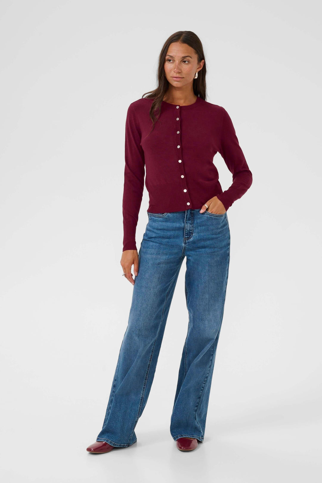 Femme portant le Cardigan Lizza classique à encolure ronde et boutons, style élégant avec jean pour un look quotidien polyvalent.