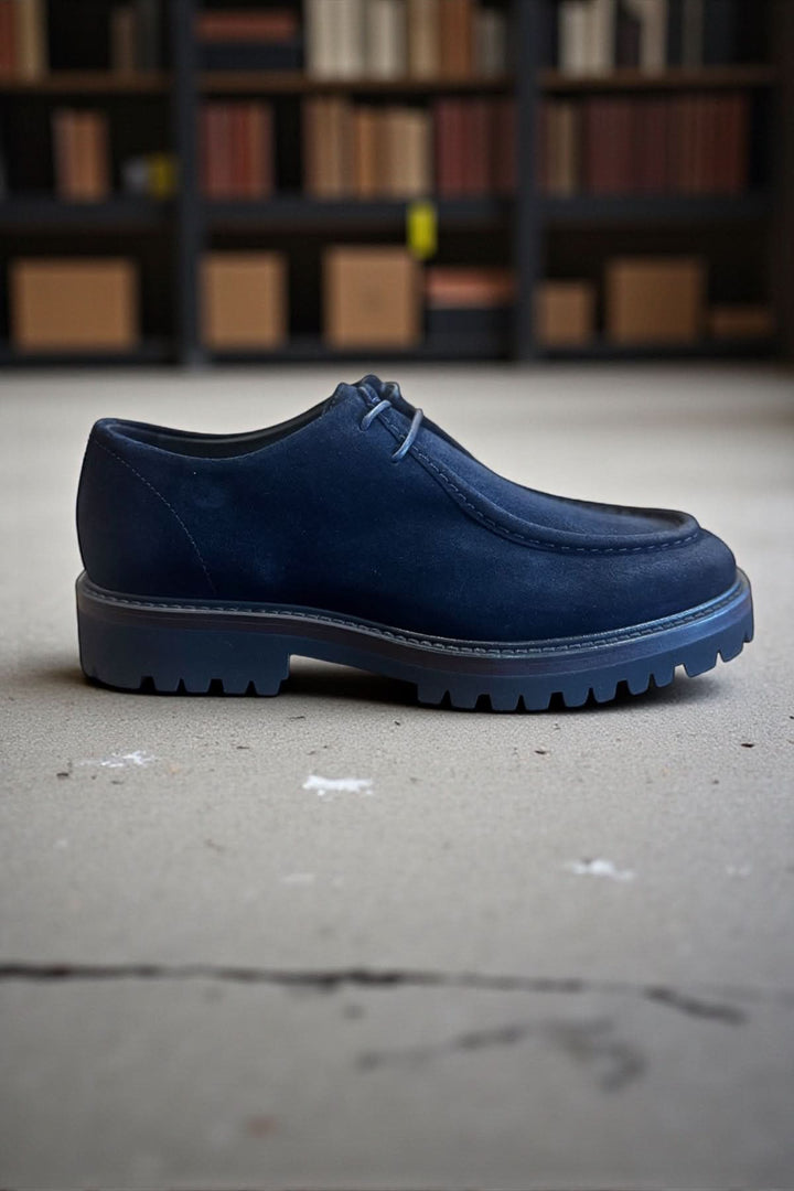 Soulier homme cuir veau suédé semelle caoutchouc bleu élégant et décontracté sur fond de bibliothèque