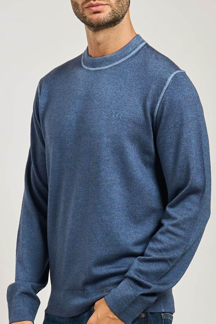 Homme portant un chandail en laine vierge à col rond de la collection BOSS Orange, couleur bleue, détail côtes, manches longues.