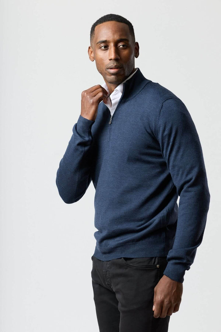 Homme portant un chandail à demi-zip en laine mérinos bleu, élégant et moderne, illustrant la sophistication décontractée italienne.
