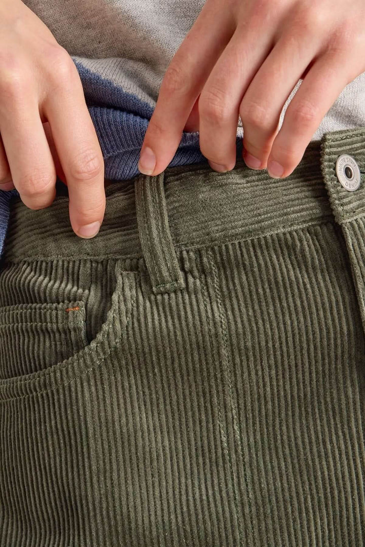 Gros plan du Pantalon Tia en velours côtelé vert avec taille haute et fermeture à bouton.