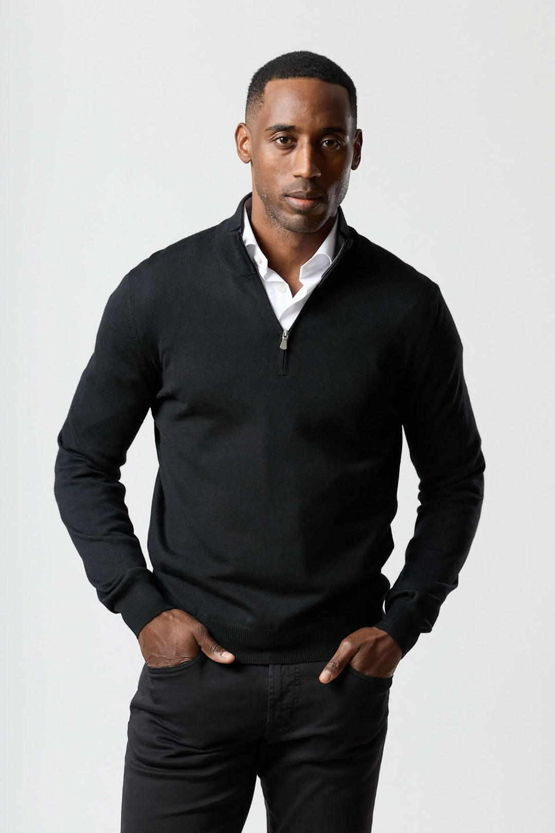Homme portant un chandail à demi-zip en laine mérinos noir élégant et moderne.