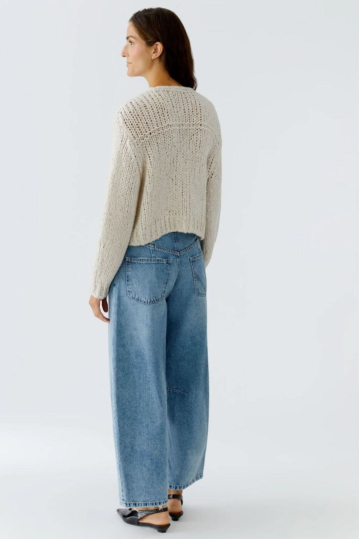 Veste en tricot épais à boutons bijoux, vue arrière, sur modèle portant un jean ample.