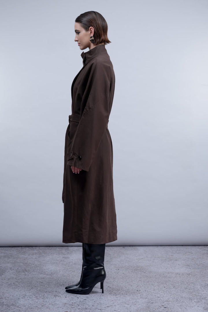 Vue de face manteau ceinturé Haako pour femme beige avec poches et bouton argenté - Valérie Simon