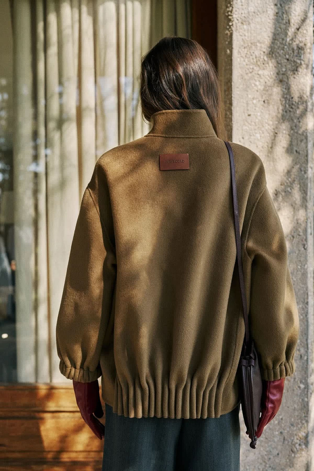 Women's mid-length coat with stand collar and puff sleeves, front view Indi & cold