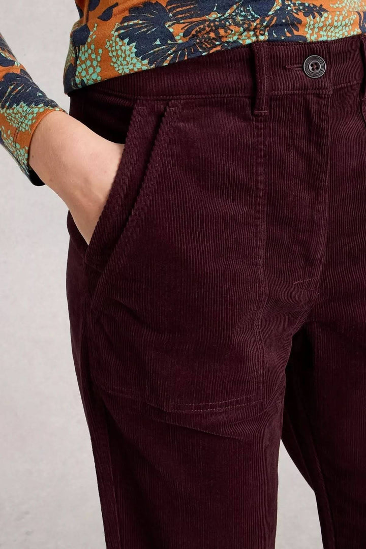 Pantalon Twister en velours côtelé bordeaux avec poches plaquées, coupe droite fuselée, porté avec un haut imprimé.