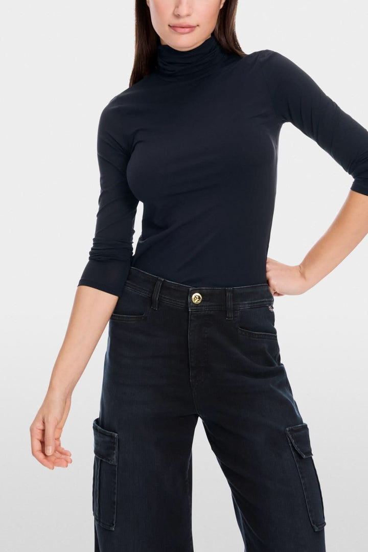 Chandail col roulé mince en noir, coupe légèrement cintrée et tissu extensible pour un confort optimal.