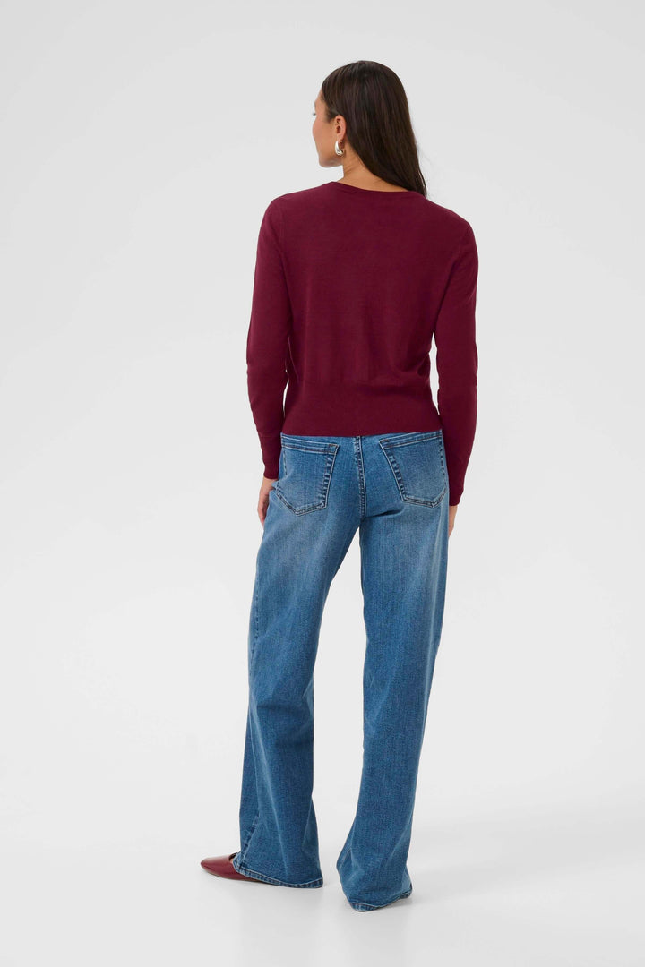 Femme portant un Cardigan Lizza classique à encolure ronde et boutons, vu de dos, avec un jean bleu.