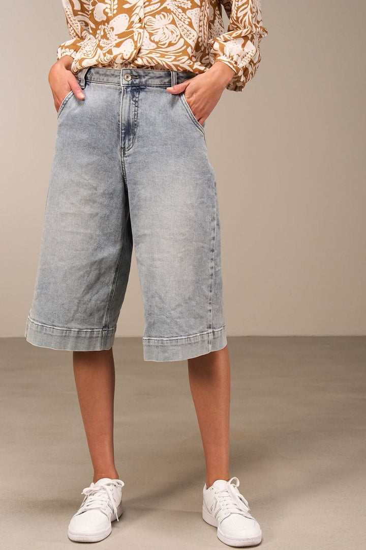 Bermuda ample en denim délavé, longueur genou, idéal pour un style décontracté et confortable.