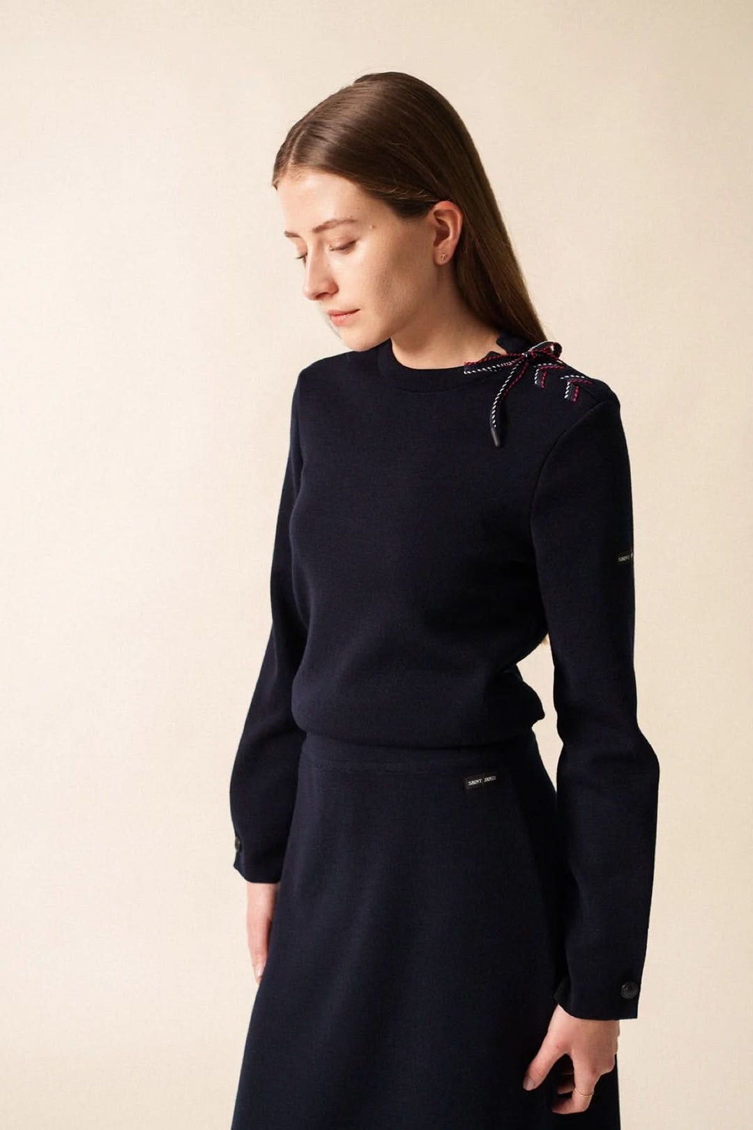 Chandail en maille à détail nœud sur l’épaule avec manches longues pour un look chic et élégant. Décris moi le produit en français.