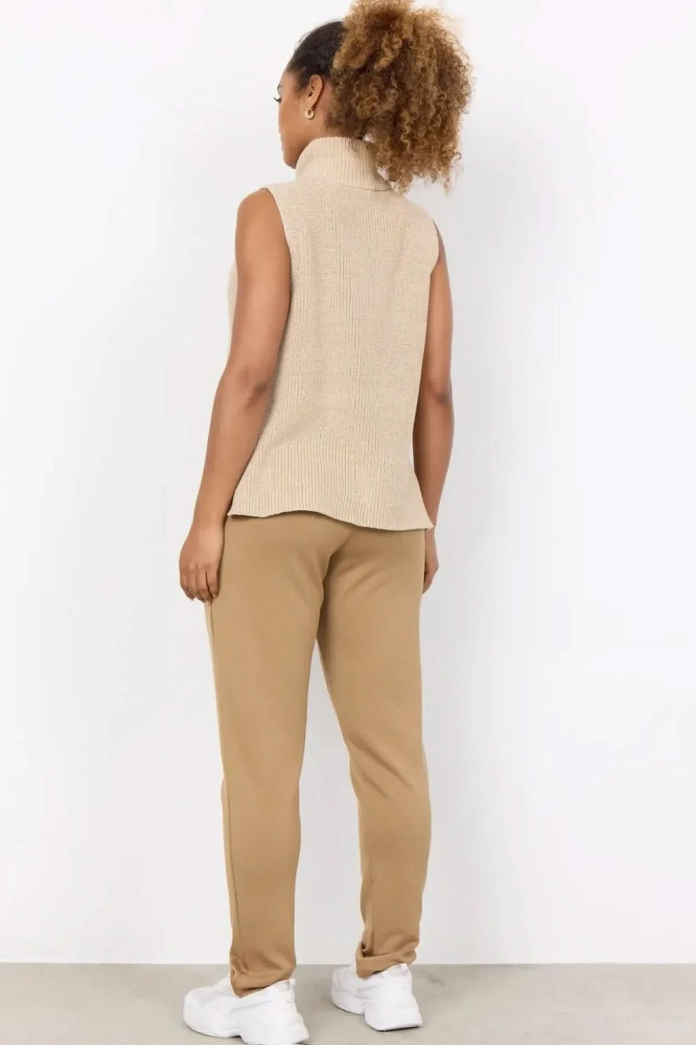 Vue arrière d'un débardeur en maille beige, associé à un pantalon décontracté beige, style moderne et sport-chic.