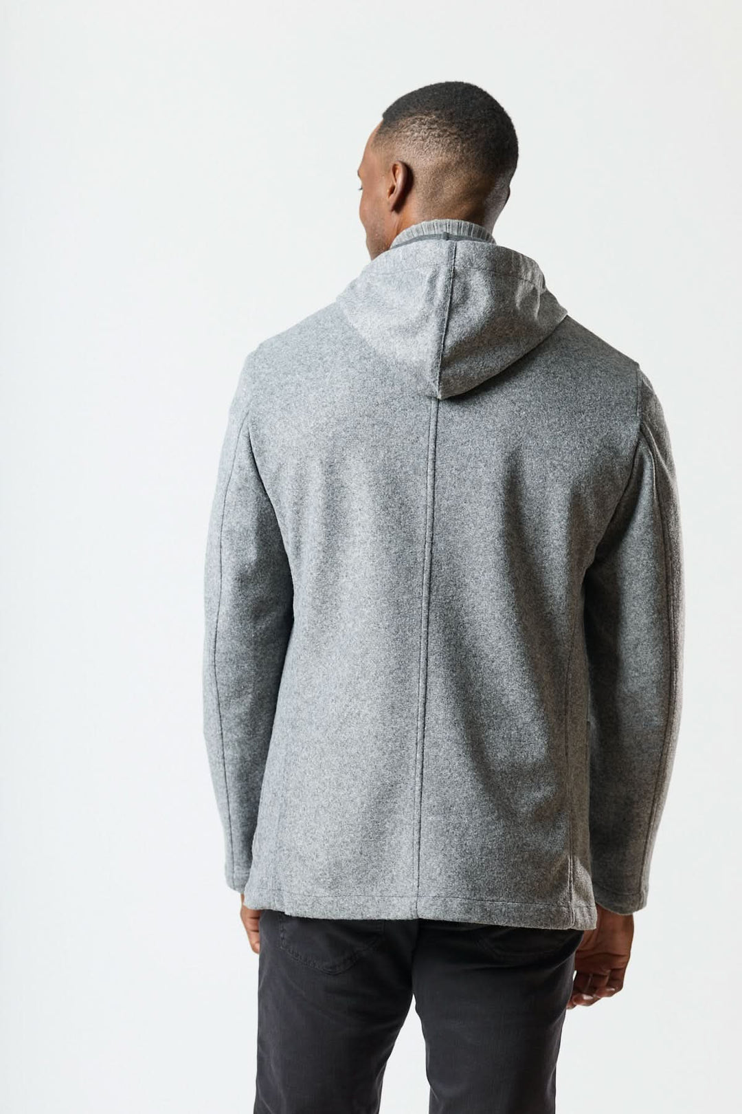 Veston hybride à capuche en laine foulée grise, homme de dos, vue du design non structuré et de la capuche intégrée pour style urbain.