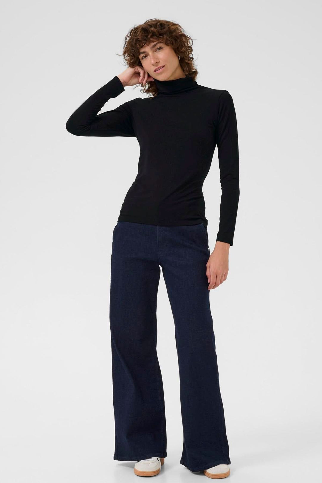 Femme portant un col roulé Efinas noir, manches longues, coupe ajustée, style classique et élégant, idéal pour superposition.