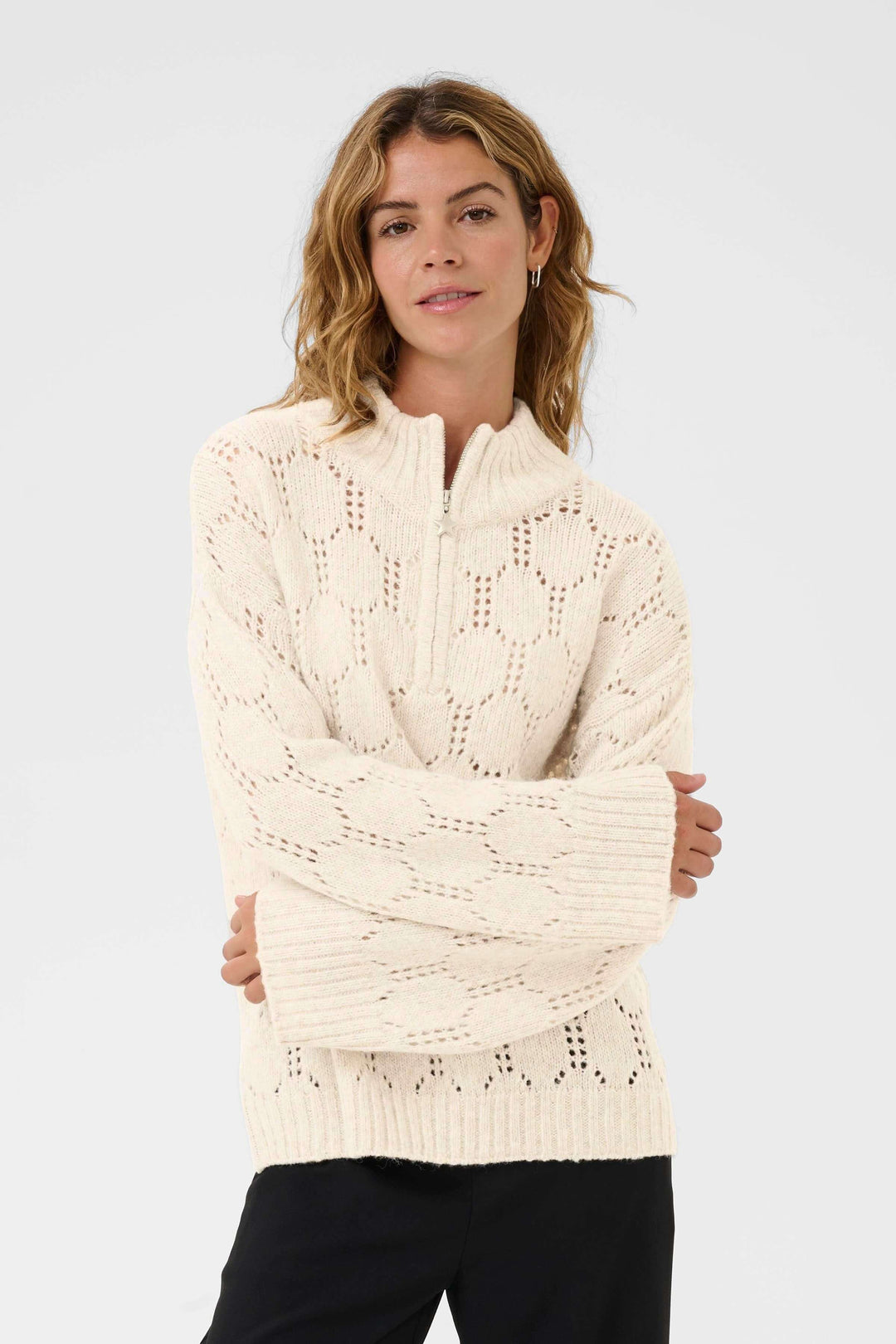 Femme portant le Chandail Zilla ajouré à demi-fermeture éclair en tricot texturé, idéal pour un style chic et décontracté.