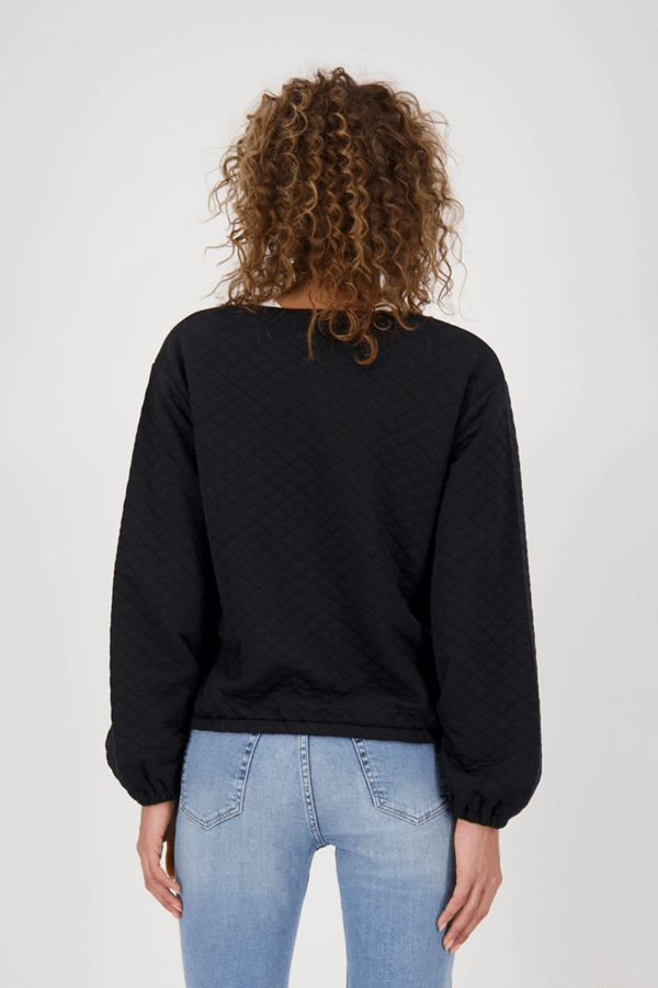 Femme portant une veste matelassée avec poches vue de dos, style moderne et élégance décontractée.