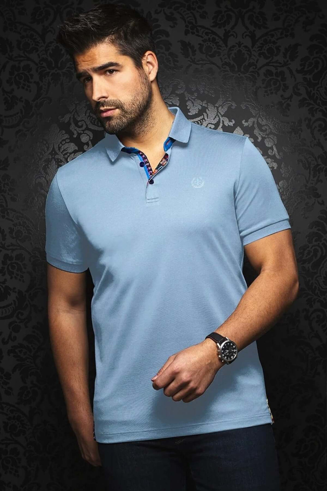 Homme portant un polo bleu uni avec détail contrastant, style sport élégant sur fond noir.