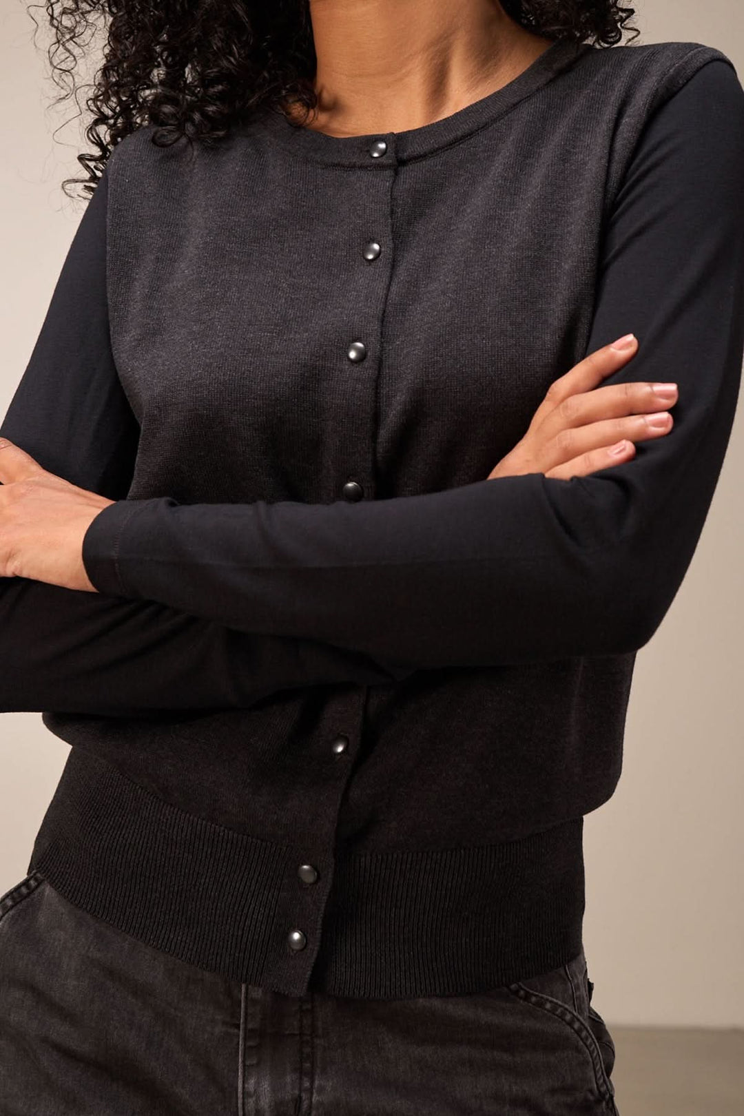 Veste sans manches élégante en maille fine, boutons-pression et coupe droite, idéale pour un look chic.