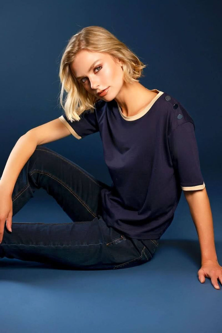 T-shirt à boutons décoratifs sur l’épaule en jersey bleu avec bordures contrastantes, porté avec un look chic et décontracté.