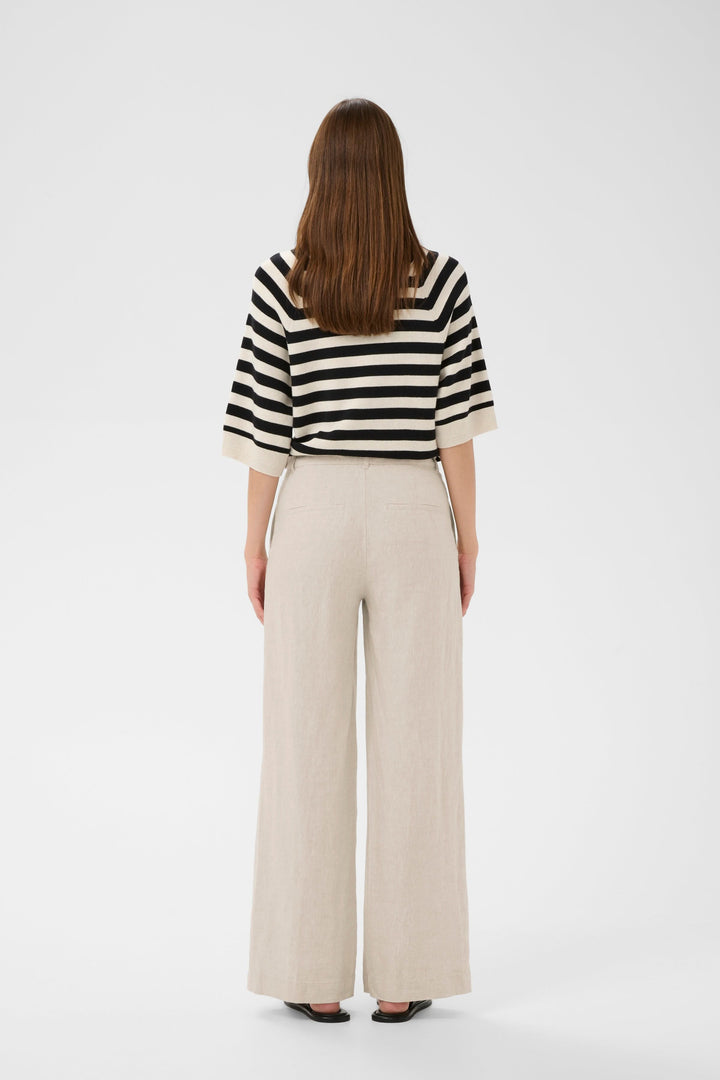 Arrière du Pantalon de lin Solina, taille haute et jambe large, porté avec une chemise rayée.