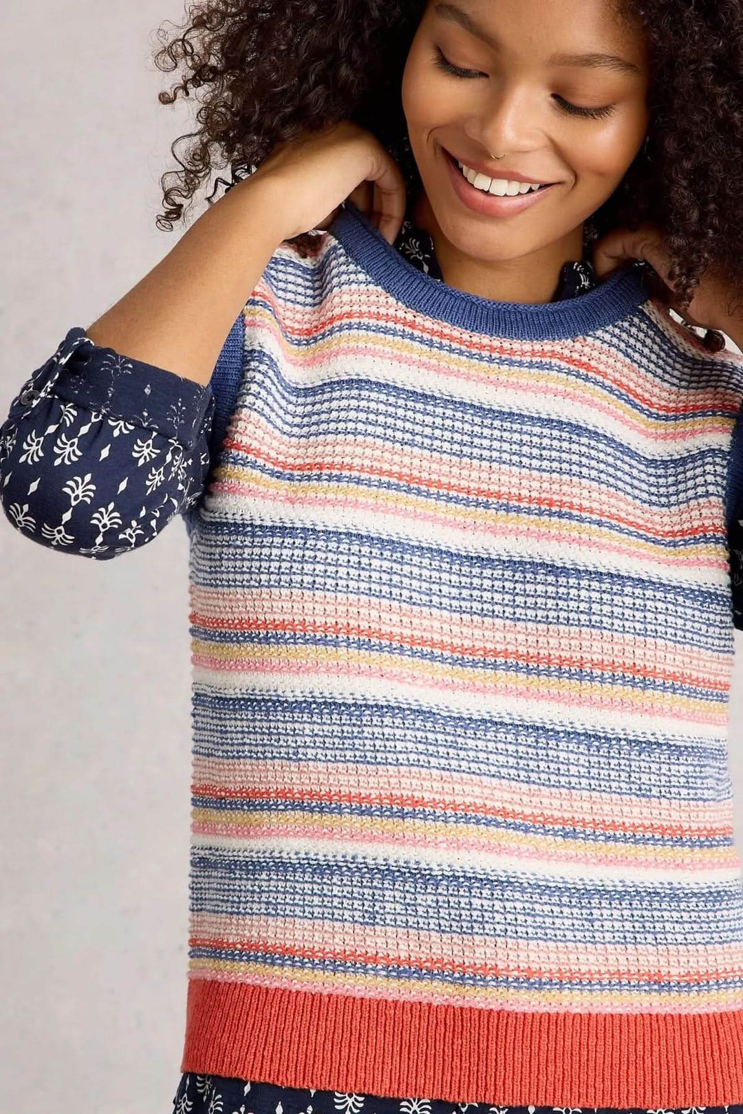 Veste sans manche Tara tricotée avec rayures multicolores et maille texturée, style rétro moderne pour superposition élégante.