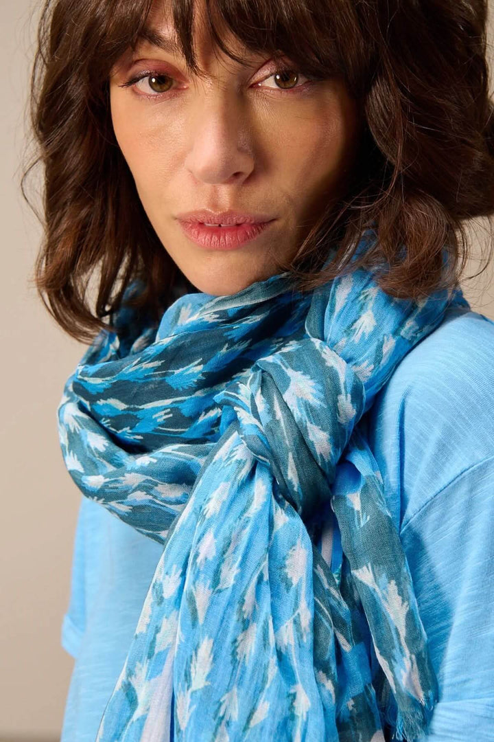 Foulard léger à imprimé bleu avec tissu fluide et franges délicates, porté pour un look élégant et polyvalent. Accessoire quotidien chic.