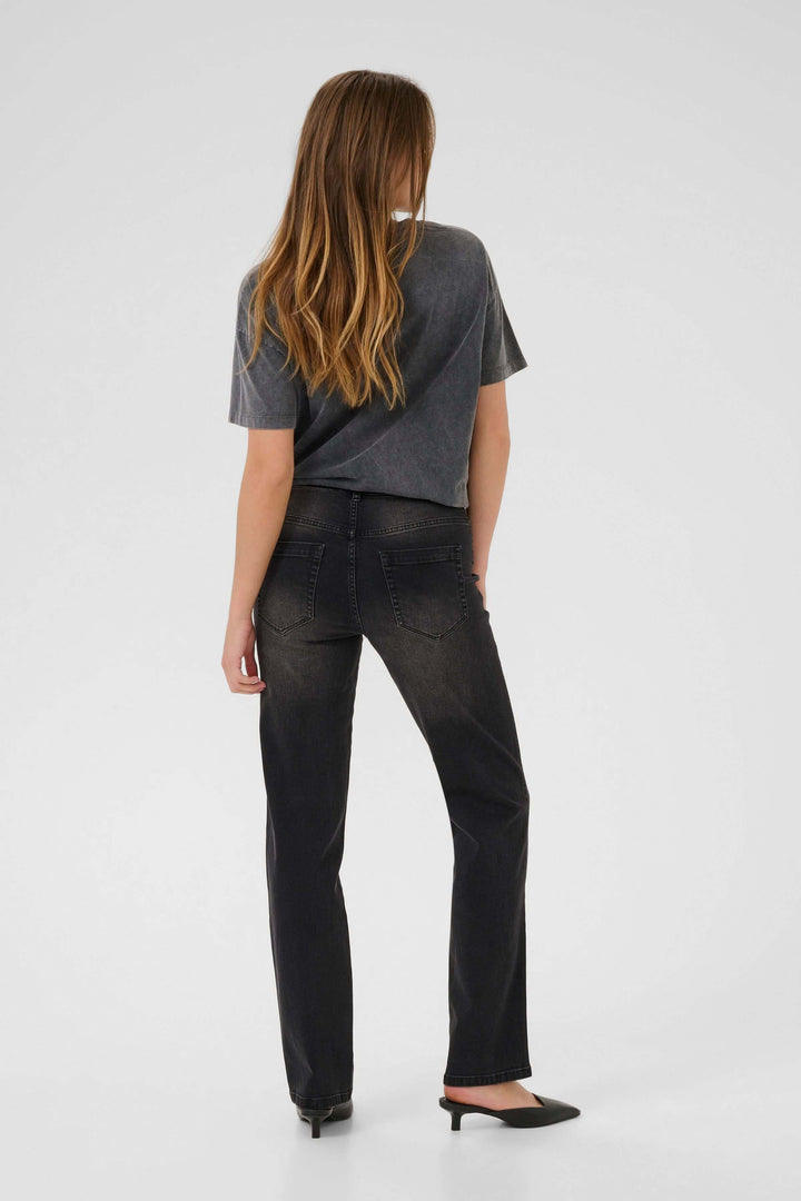 Modèle portant le Jean Maris coupe droite taille classique, noir délavé, avec t-shirt gris, vue de dos, ambiance moderne.