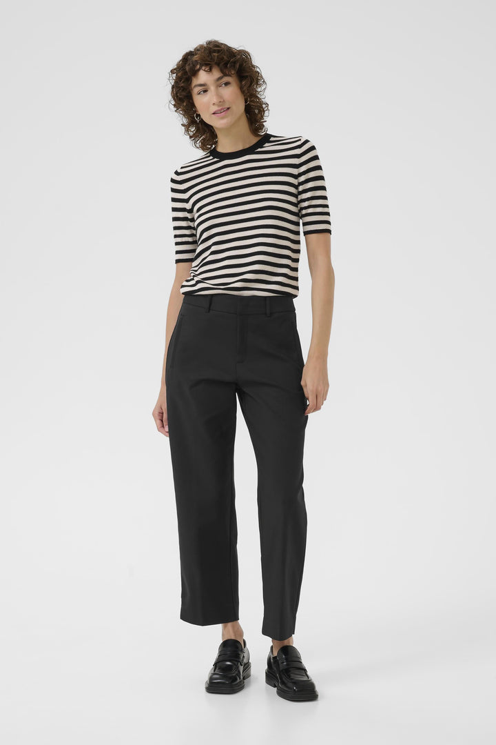 Femme portant un pantalon Neyana classique à jambe droite avec t-shirt rayé, look soigné et moderne.