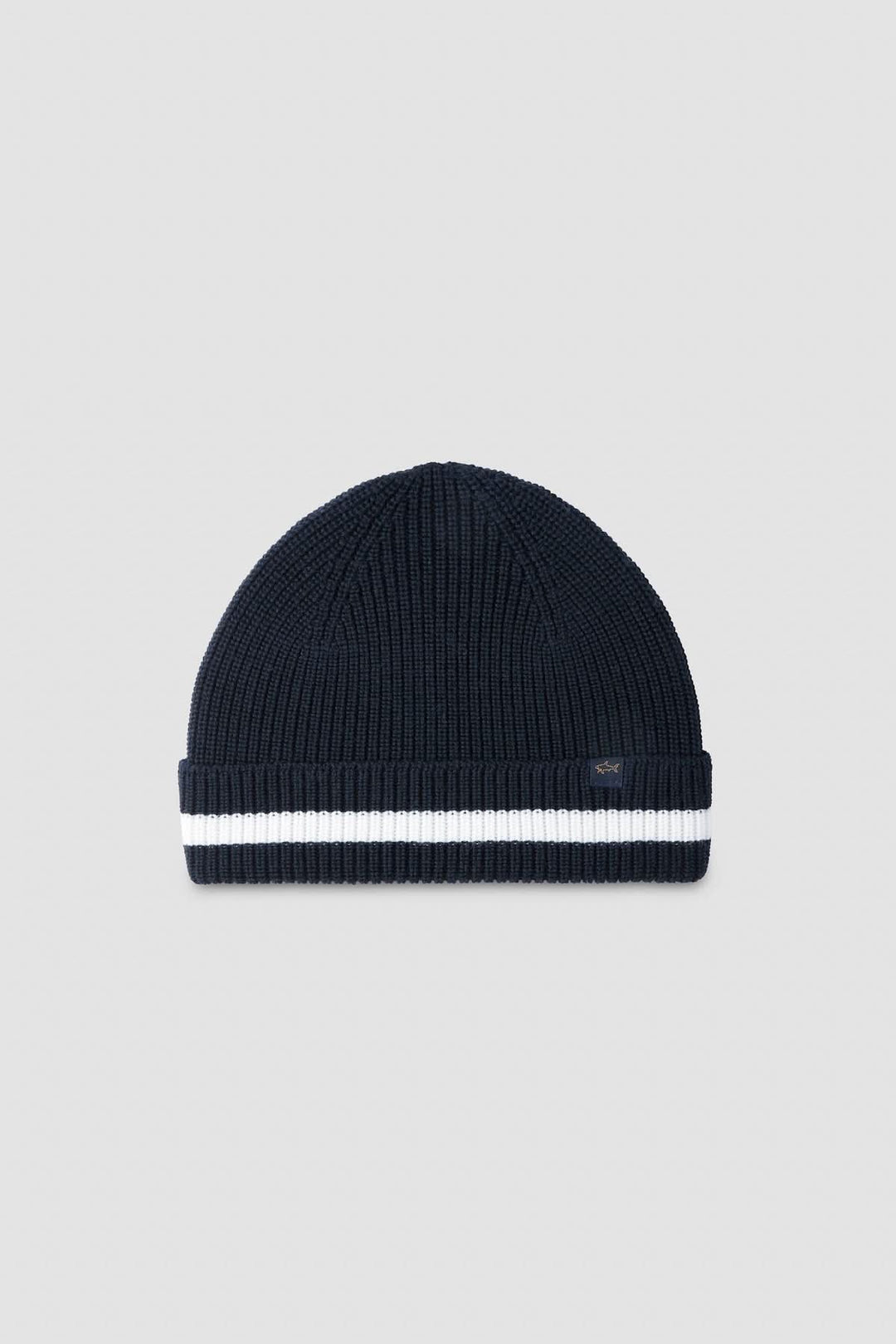 Tuque en tricot côtelé bleu marine avec bande blanche pour un style hivernal moderne et élégant.
