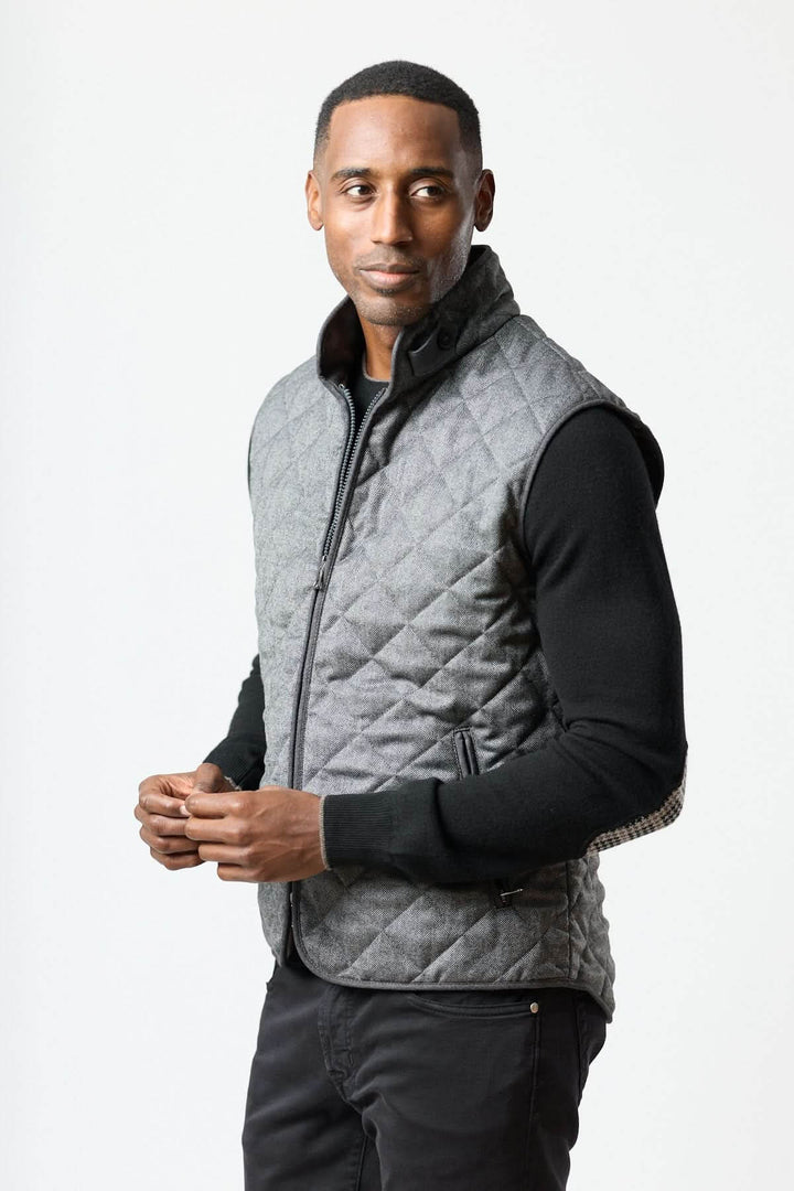 Homme portant une veste sans manches matelassée en laine à motif chevrons, élégance italienne avec texture chaude et légère.