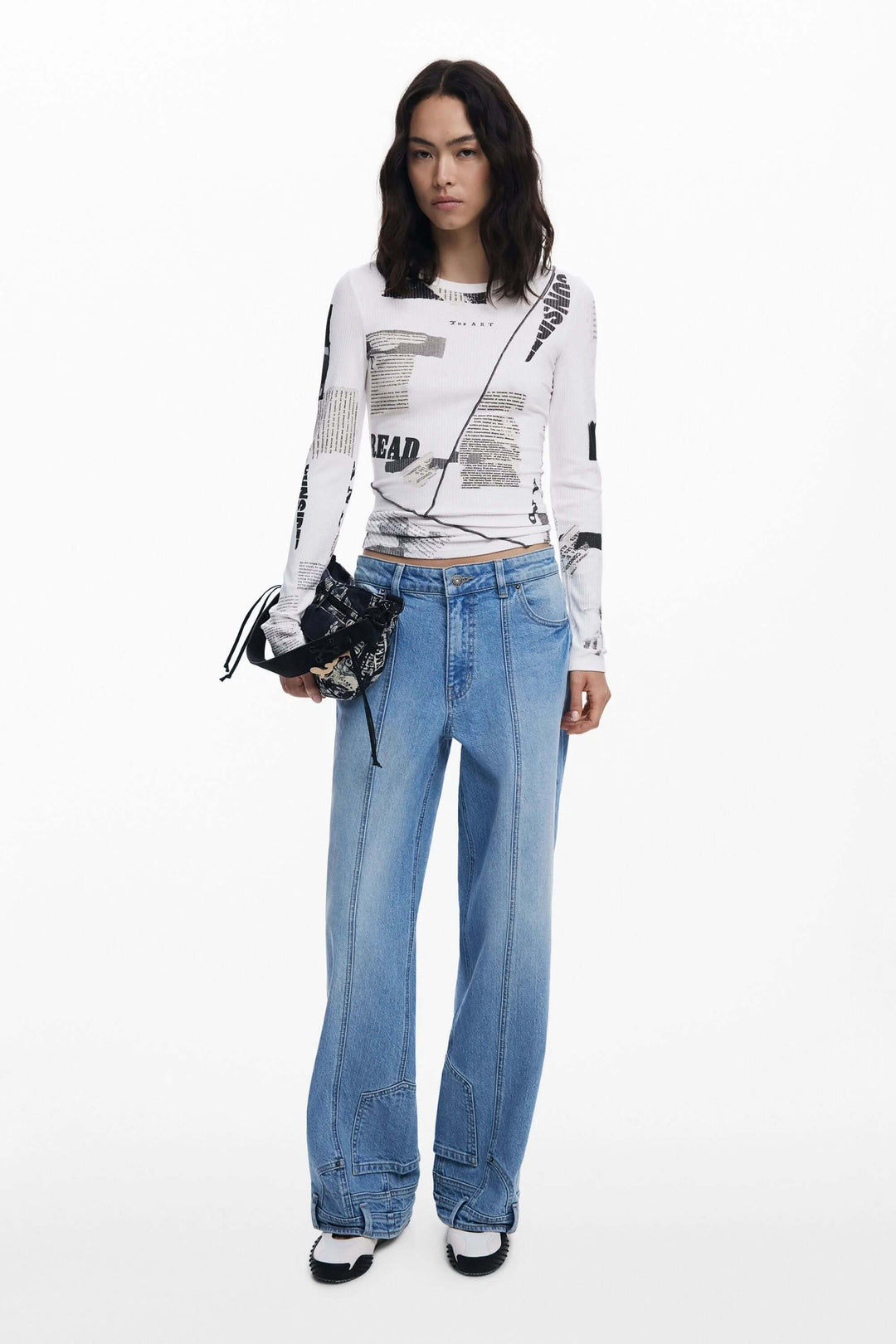 T-shirt à manches longues Mickey avec imprimé typographique, porté avec un pantalon en denim et un sac moderne.