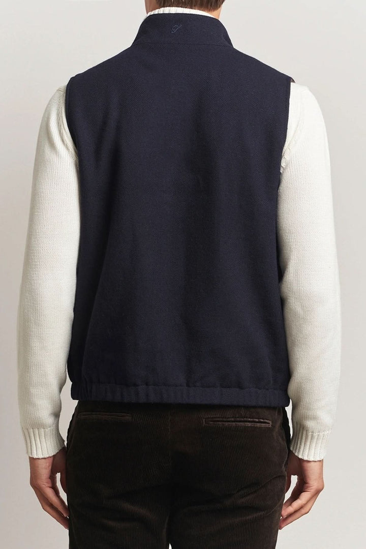Homme portant un gilet en laine réversible bleu marine de dos, avec des manches blanches, idéal pour une tenue élégante et confortable.
