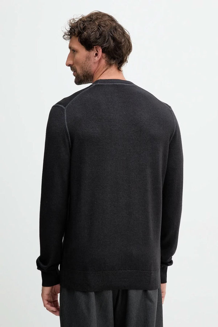 Homme portant un chandail en laine vierge à col rond noir dos vue. Confortable et élégant, avec finitions côtes. Décris moi le produit en français.