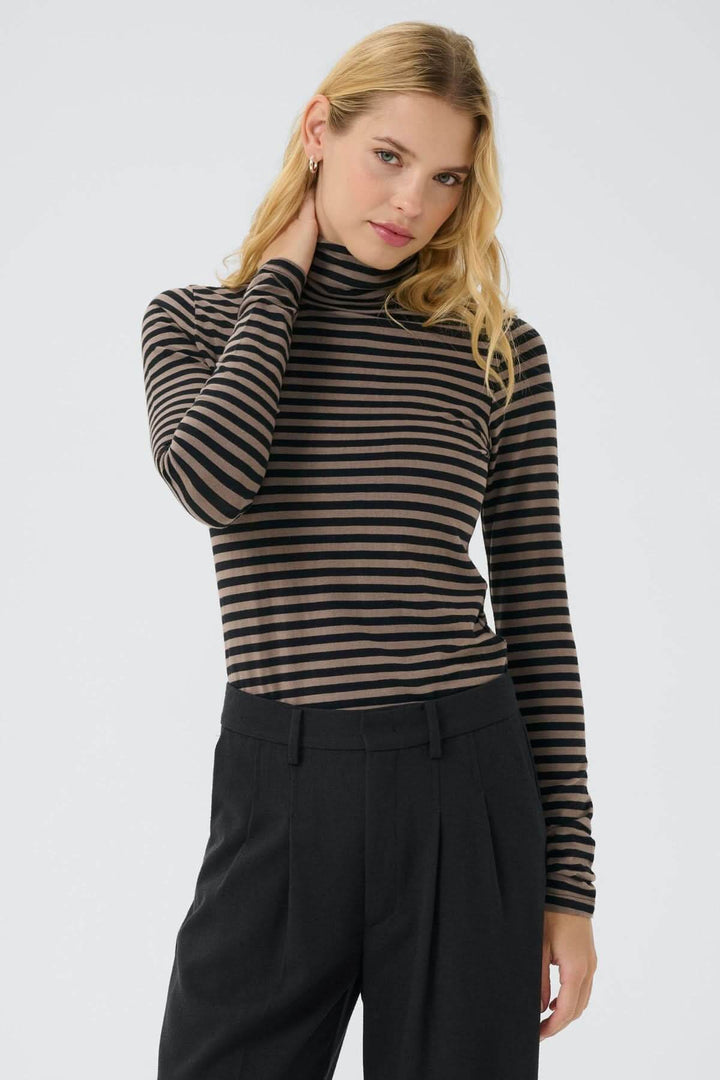 Femme portant un col roulé Efinas rayé noir et marron, manches longues, coupe ajustée, élégance polyvalente et confortable.