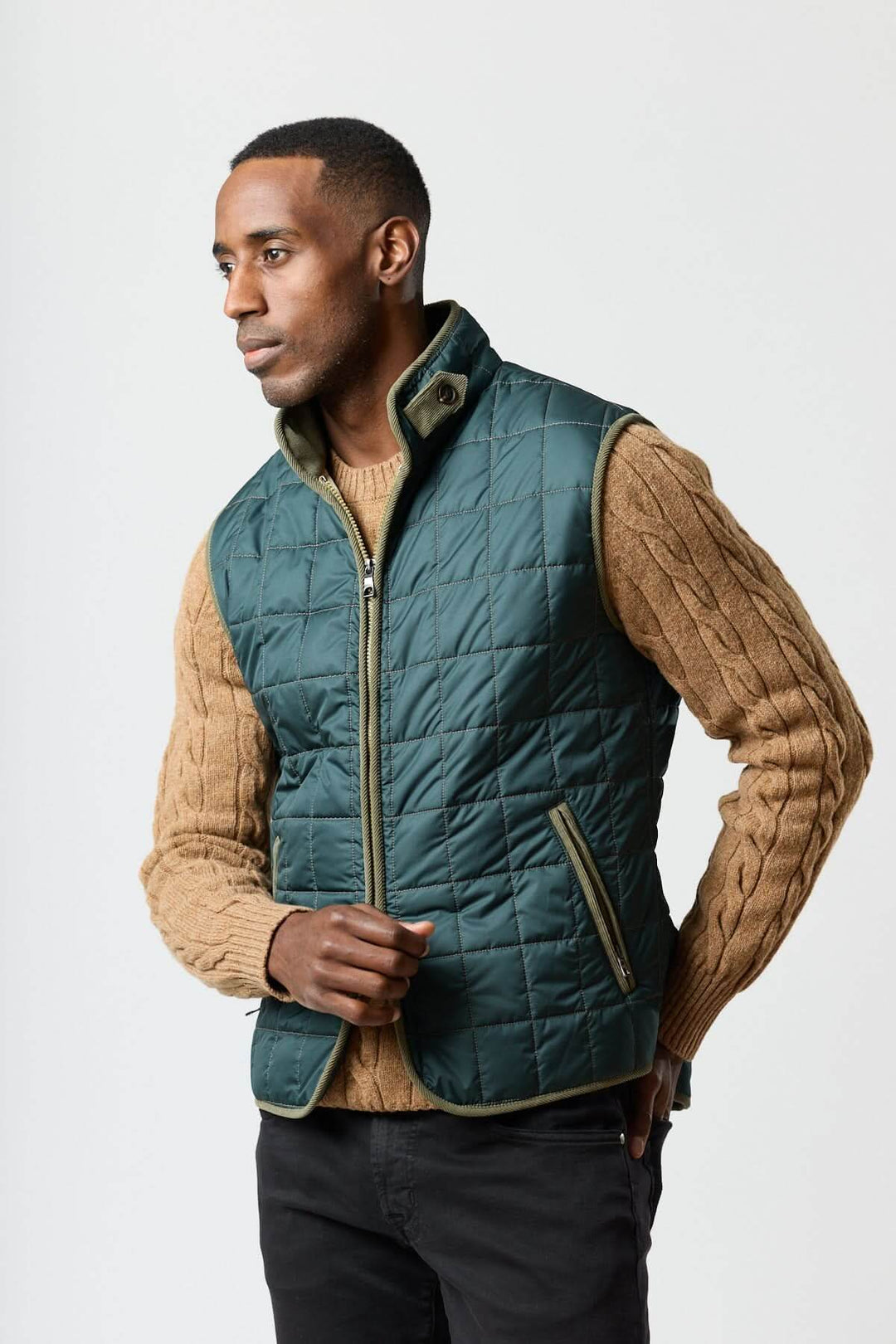 Alt Tag: Homme portant une veste sans manches matelassée avec détails en velours côtelé, idéale pour un style élégant et pratique.