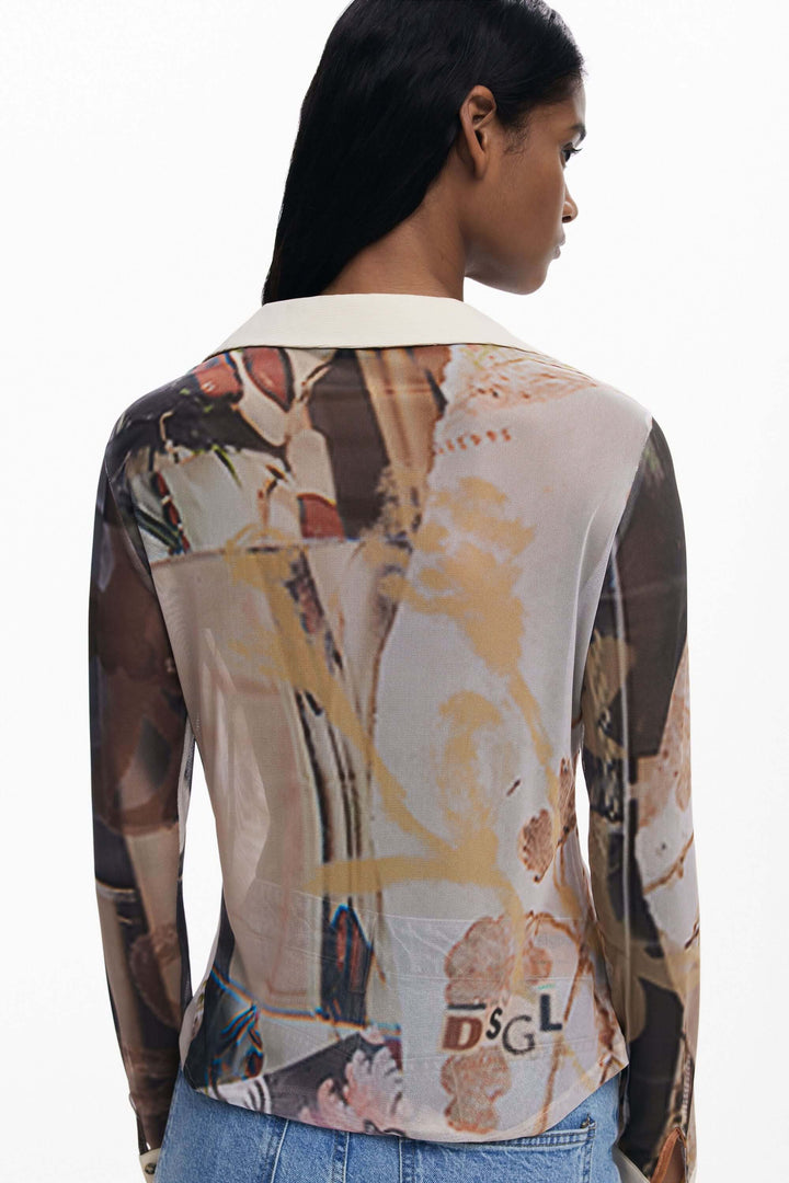 Femme portant un T-shirt en mousseline avec poignets, imprimé artistique, col contrasté, coupe ajustée, style graphique et élégant.