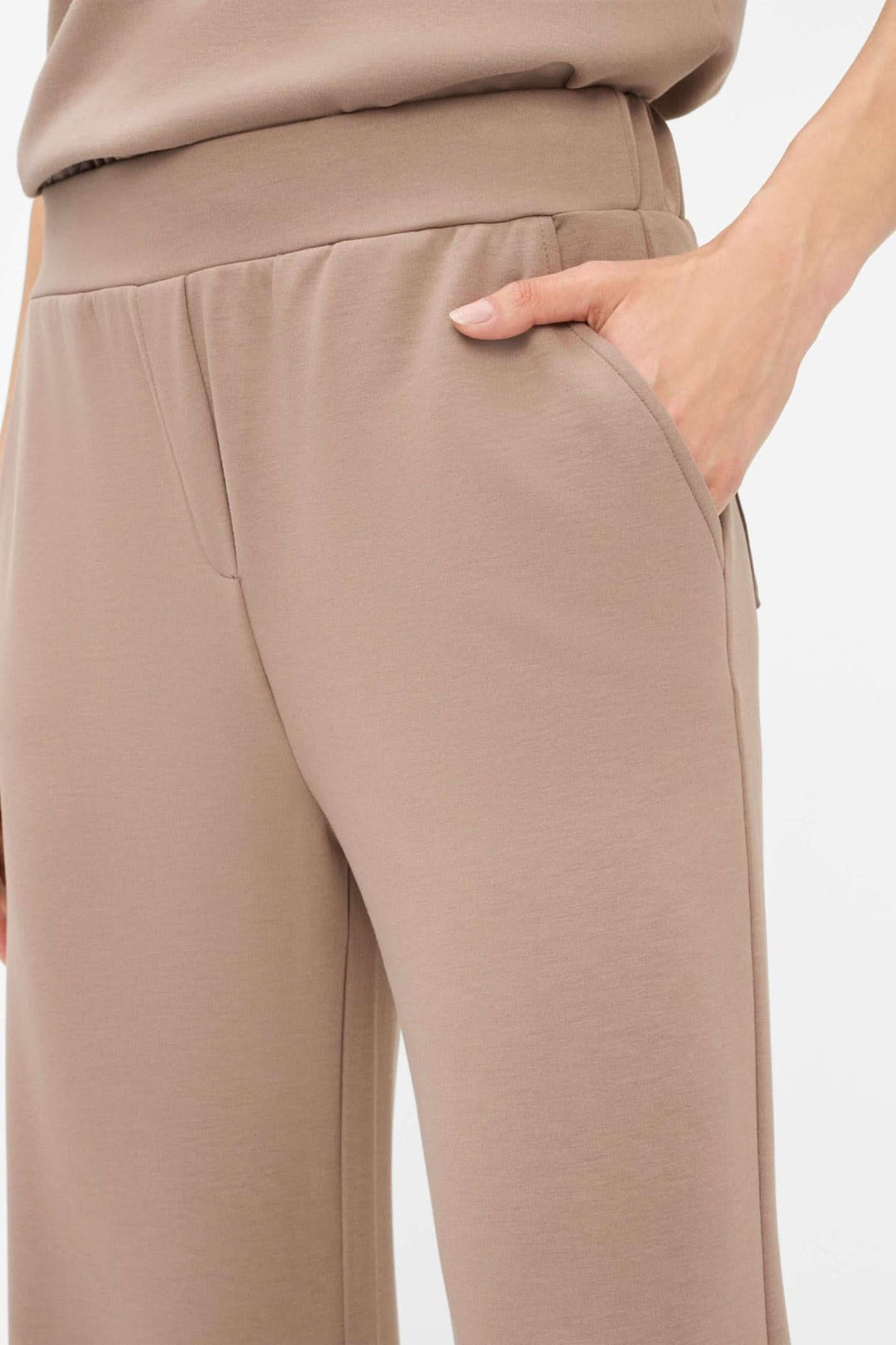 Détail du pantalon palazzo Maine, couleur beige, avec taille élastique et poches, offrant confort et style moderne.