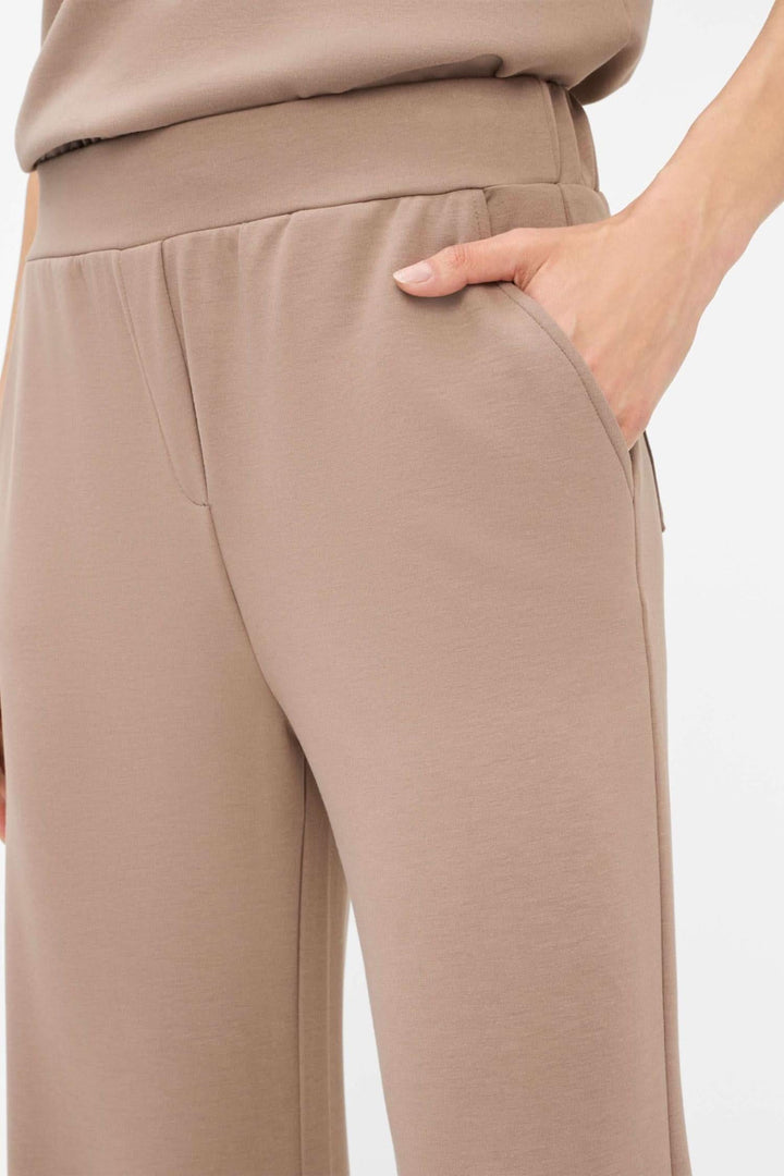 Détail du pantalon palazzo Maine, couleur beige, avec taille élastique et poches, offrant confort et style moderne.