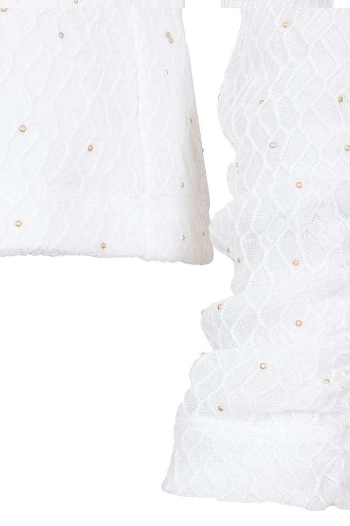 Chandail à col montant blanc, maille fine avec éclats scintillants pour un look élégant en soirée.