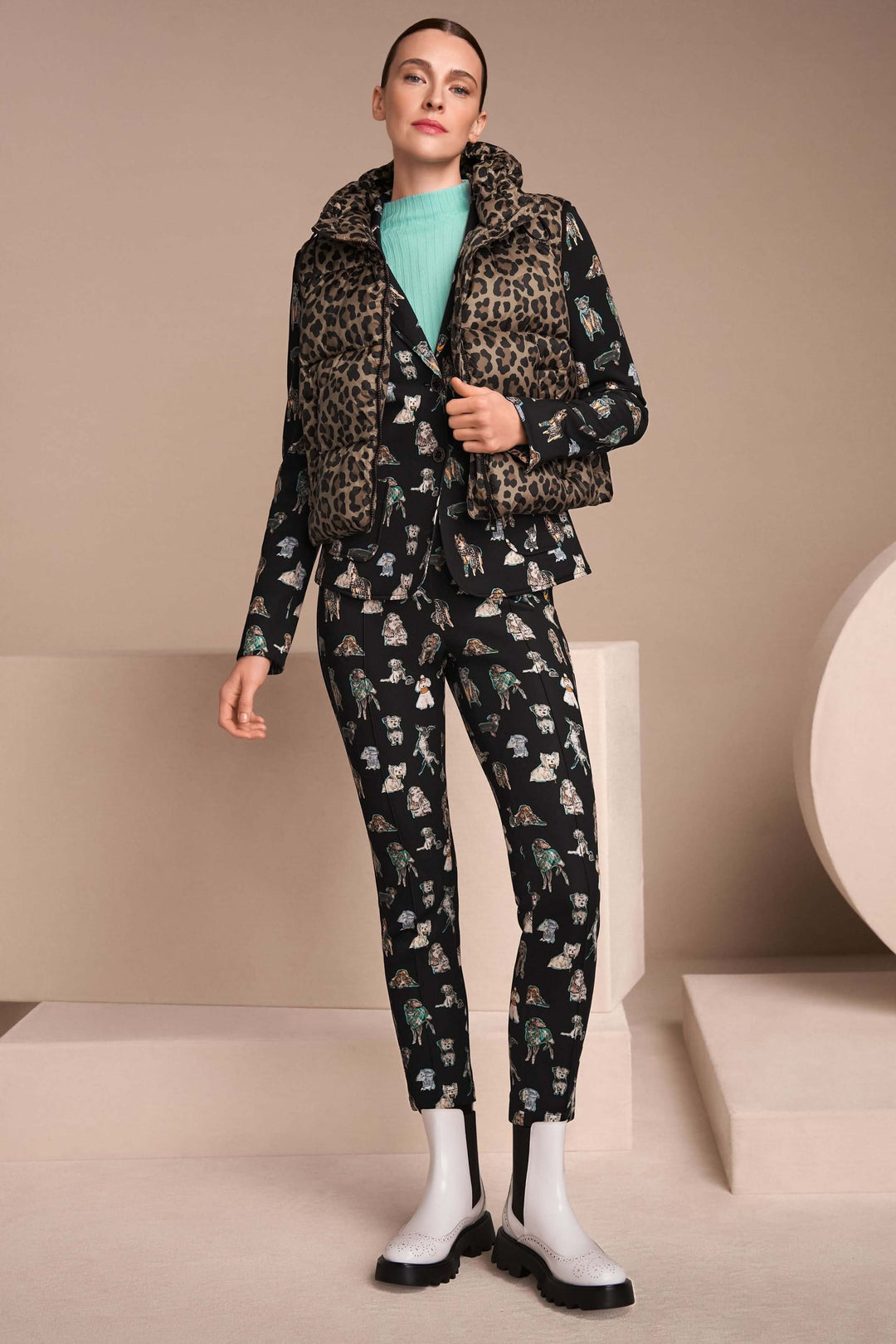 Femme portant une veste matelassée à imprimé léopard et capuchon, associée à un ensemble chic, ambiance élégante.