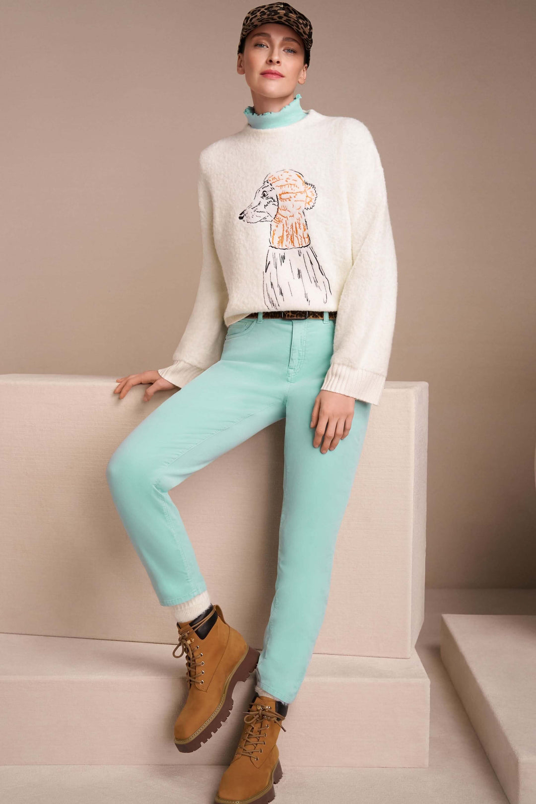 Femme portant un chandail à col montant et bordures ondulées dans une tenue mode casual.