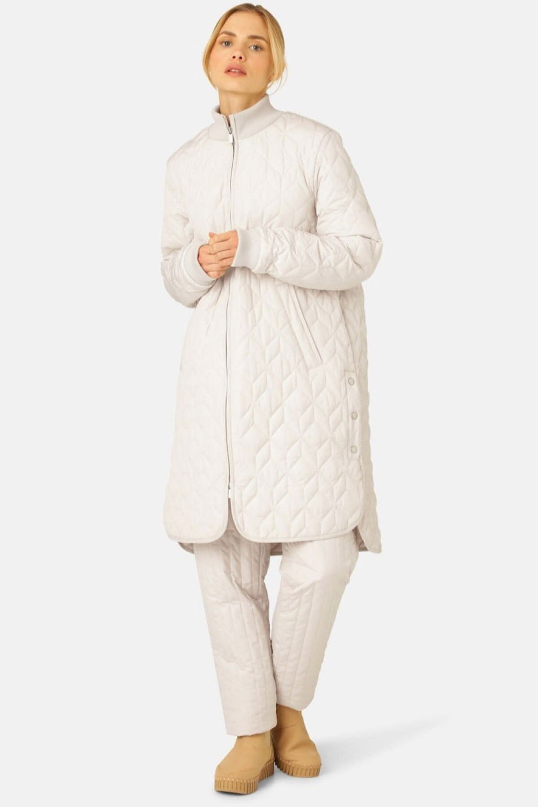 Manteau matelassé léger, long et confortable avec motif de courtepointe, porté avec un ensemble coordonné.